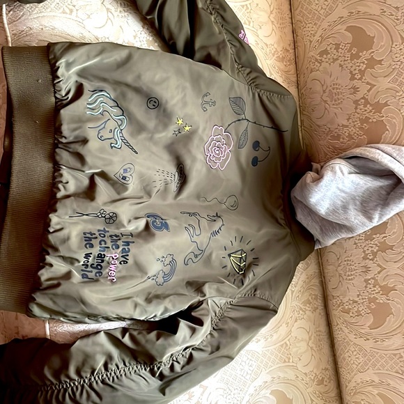 I’m selling this jacket, different designs on it. Camouflage green. Grey hood - Picture 2 of 2